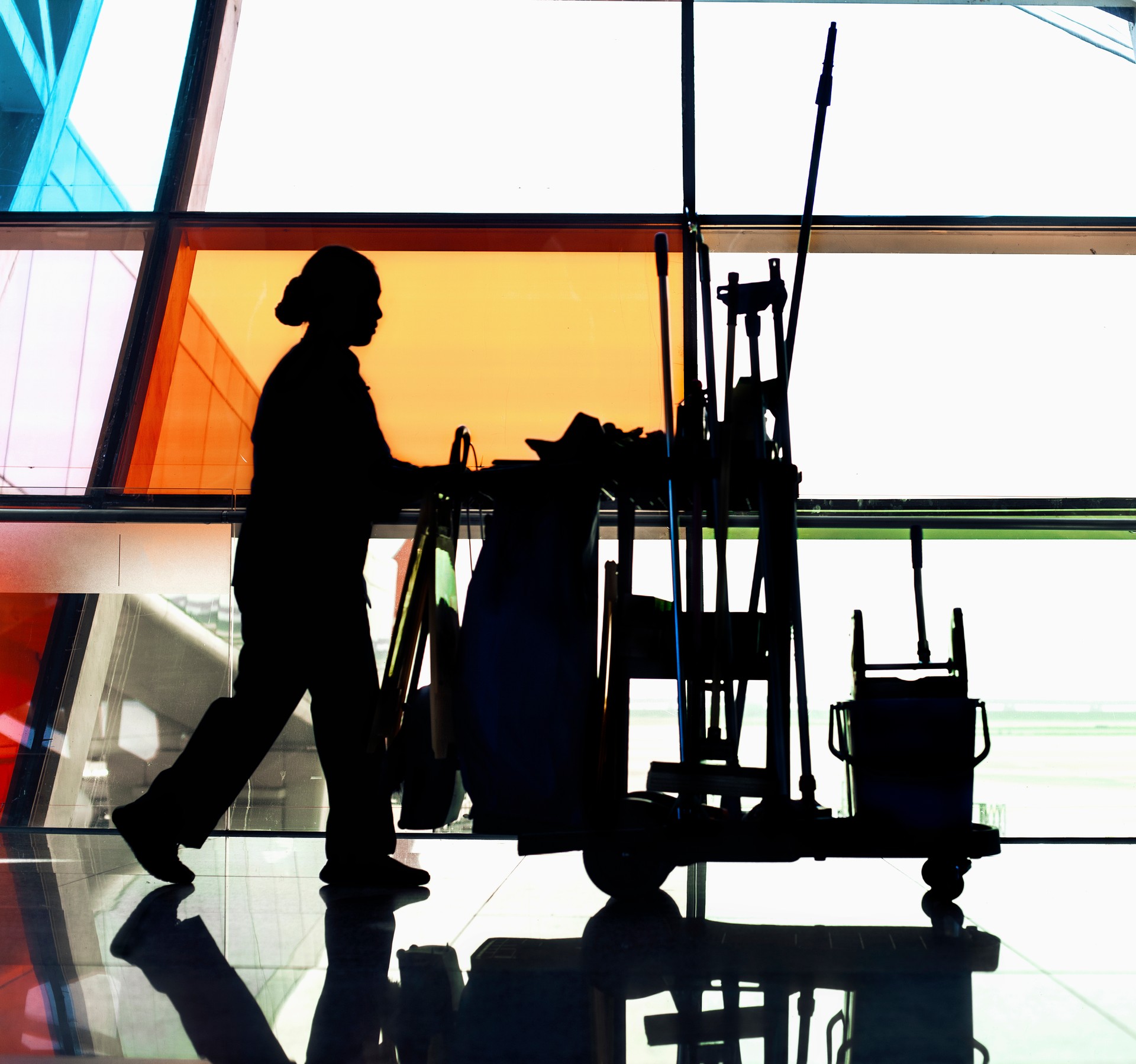 Custodian janitor pushing cleaning cart down hallway, shadow, focus on shadow, digital composite, full length, side view